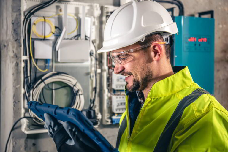 man-electrical-technician-working-switchboard-with-fuses-uses-tablet1