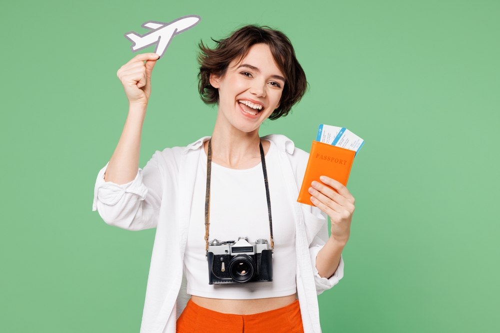 Traveler,Happy,Woman,Wear,Casual,Clothes,Hold,Passport,Ticket,Show Afla cum folosesti card avantaj WIZZ pentru zboruri si vacante.